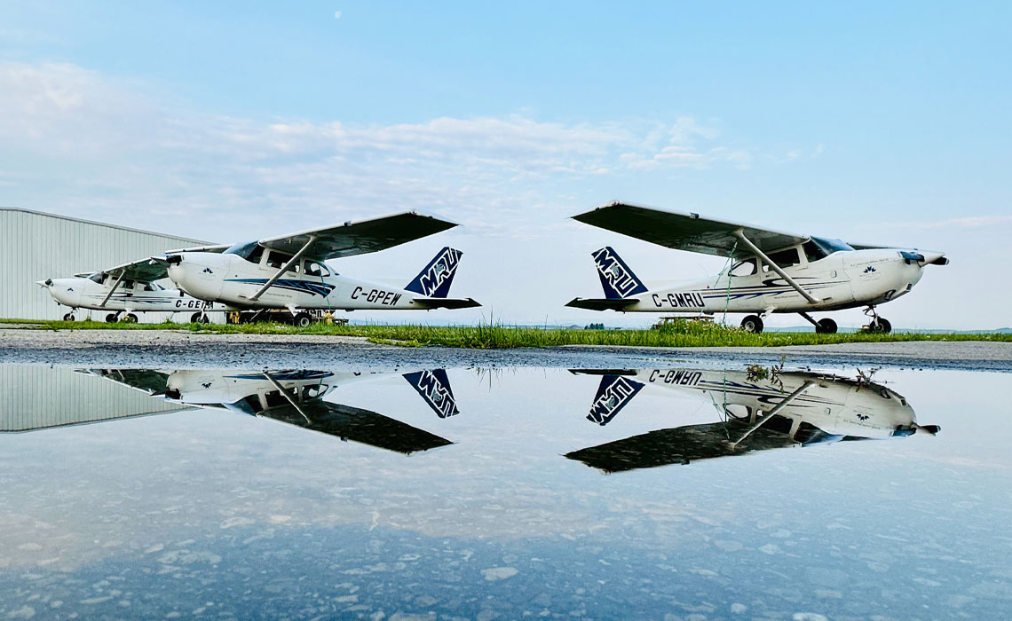 MRU airplanes parked on a wet runway.