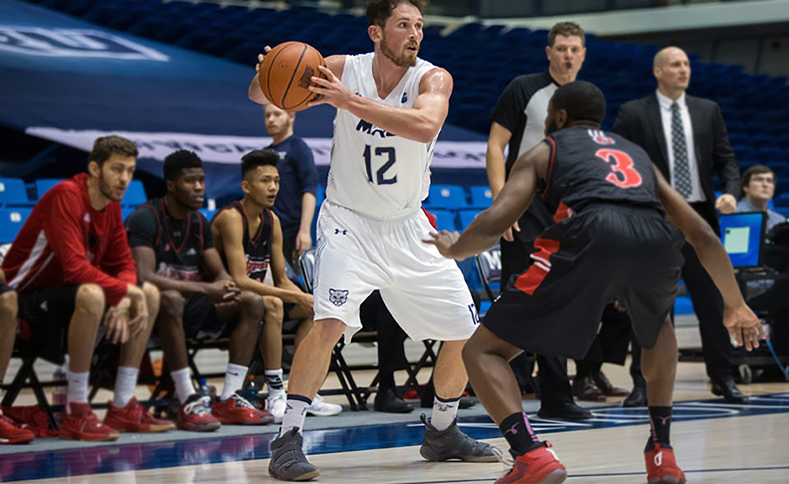 Noah Lewis prepares to pass the ball, focused and poised on the court.