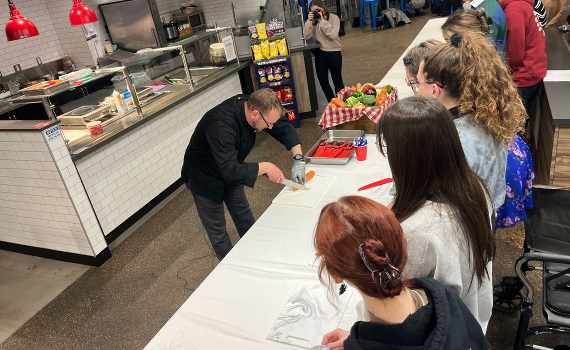 Chef Peter demonstrates to students how to safely chop vegetables.