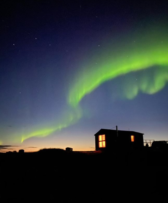 The northern lights dance in green.