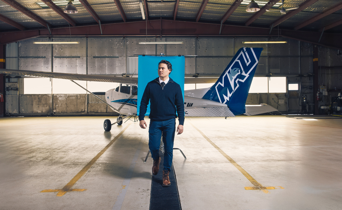 Sid Nichol stands in front of an airplane at the Mount Royal University Springbank Campus.