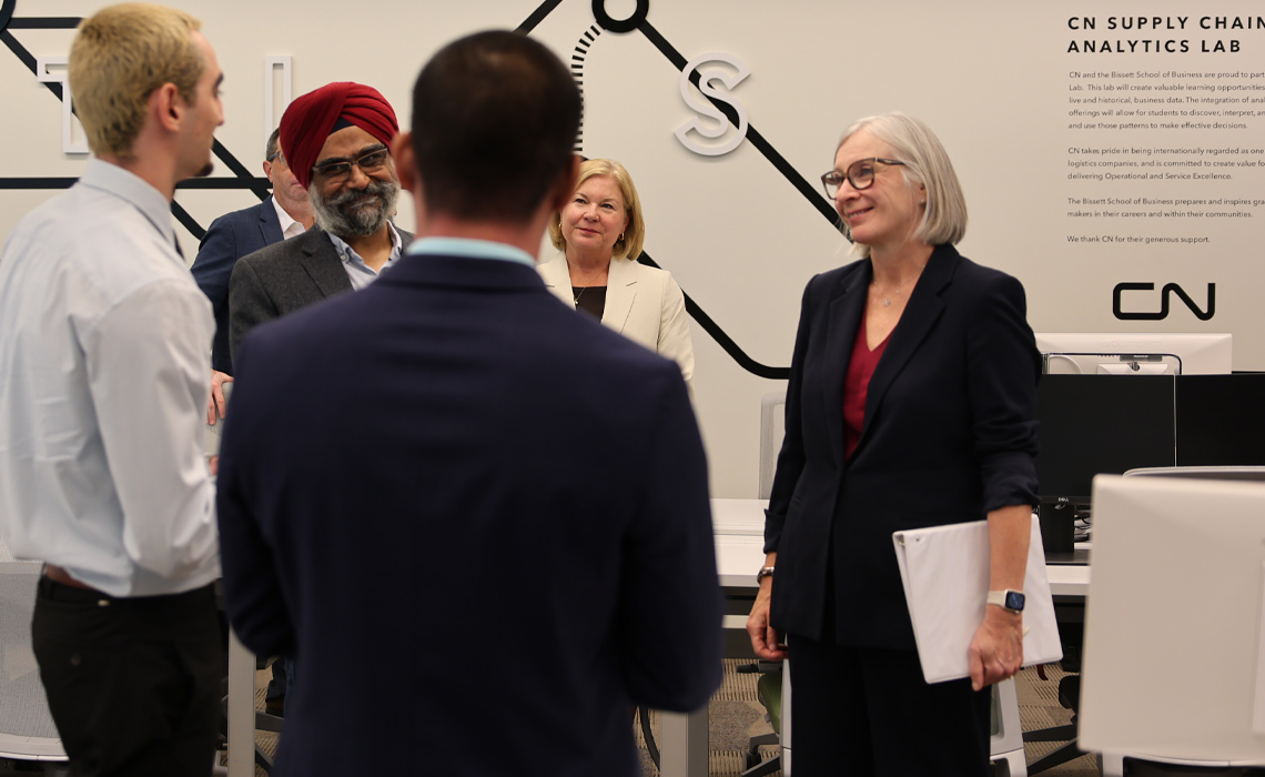 A MRU student conversing with faculty and visitors during a tour of the CN Supply Chain Analytics Lab.