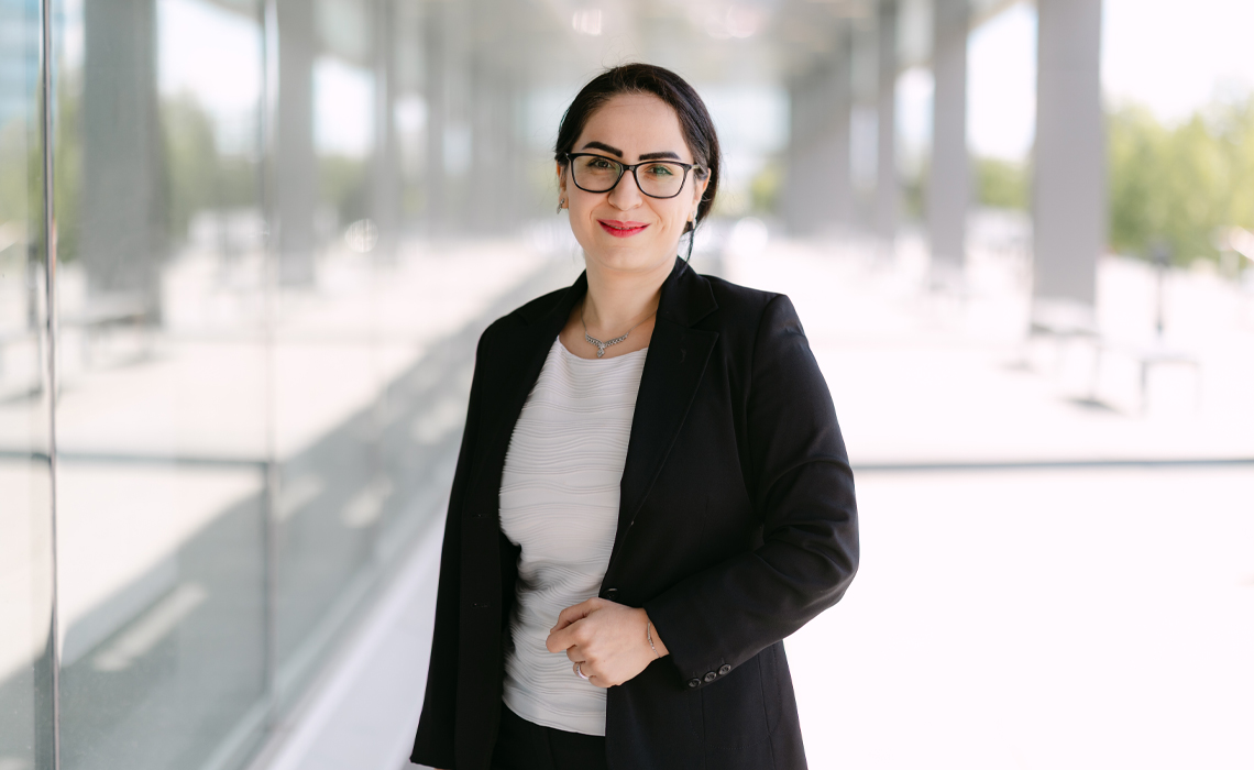 Yasaman Amannejad, PhD, stands confidently outside of the Riddell Library & Learning Centre.