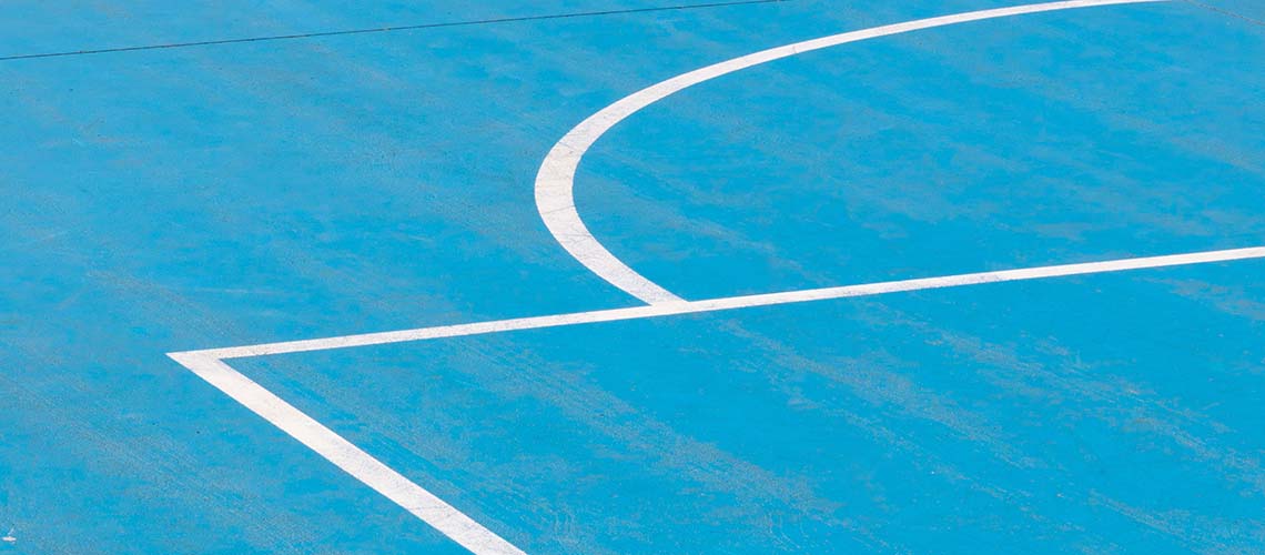 Close up photo of an outdoor basketball court.