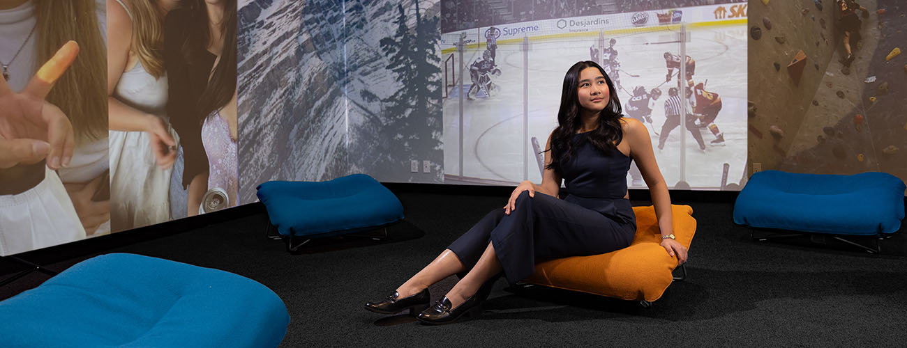 Nina Petinglay sitting on a cushion in the Riddell Library and Learning Centre's Immersion Studio.