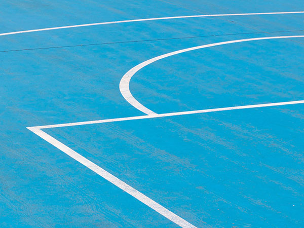 Close up photo of an outdoor basketball court.