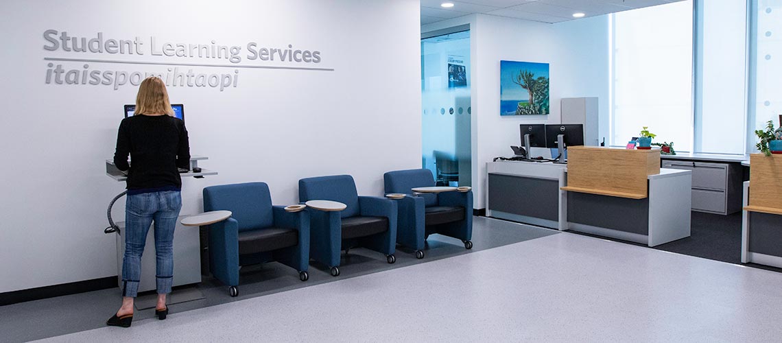 Photo of a person working at a computer in the entrance of Student Learning Services
