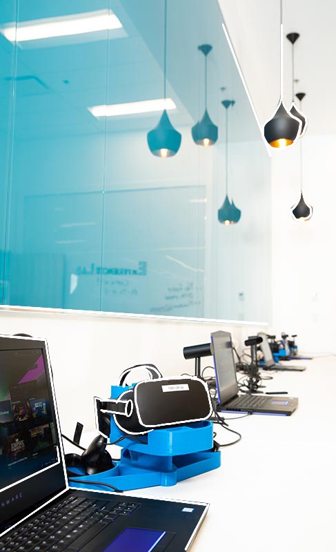 Laptops and VR headsets set up in Mount Royal University's Maker Studio.