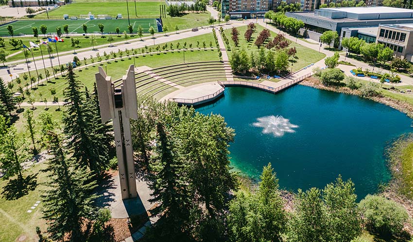 Aerial photo of campus, showing the Charlton Pond with the Kerby Memorial Tower and MRU carillon, West Residences, and soccer fields.