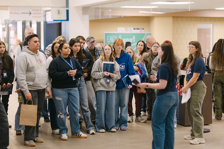 A Mount Royal tour guide giving a tour to a large group of Open House attendees.