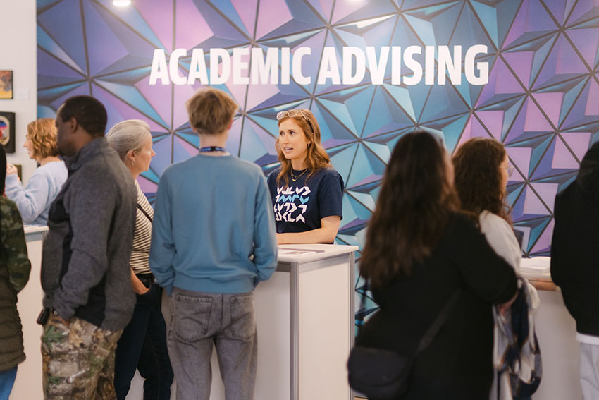An academic advisor explaining admission requirements to some Open House guests.