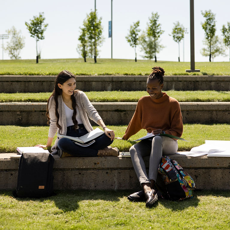 Two students studying and chatting in the TransCanada Amphitheatre.