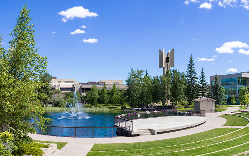 Grassy steps of the leading to an outdoor stage of the TransCanada Amphitheatre in front of a fountain in the Charlton Pond.