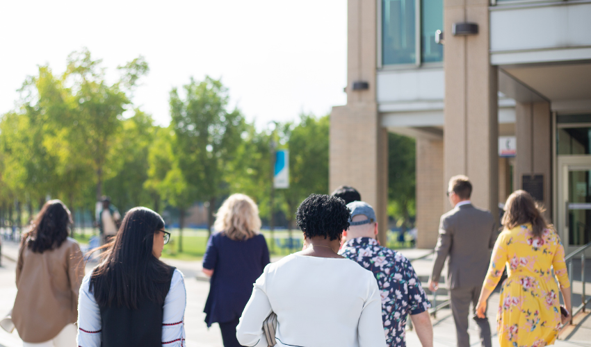 Members of the Alumni Council walking through the East Gate lawn.