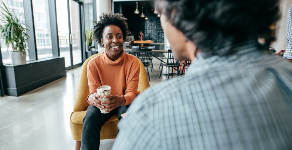 Two people talking and having coffee.
