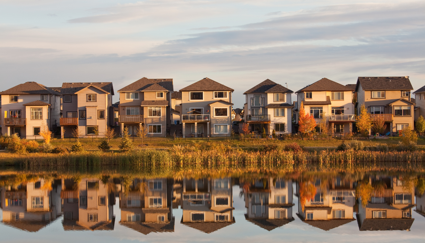 Houses across a still lake.