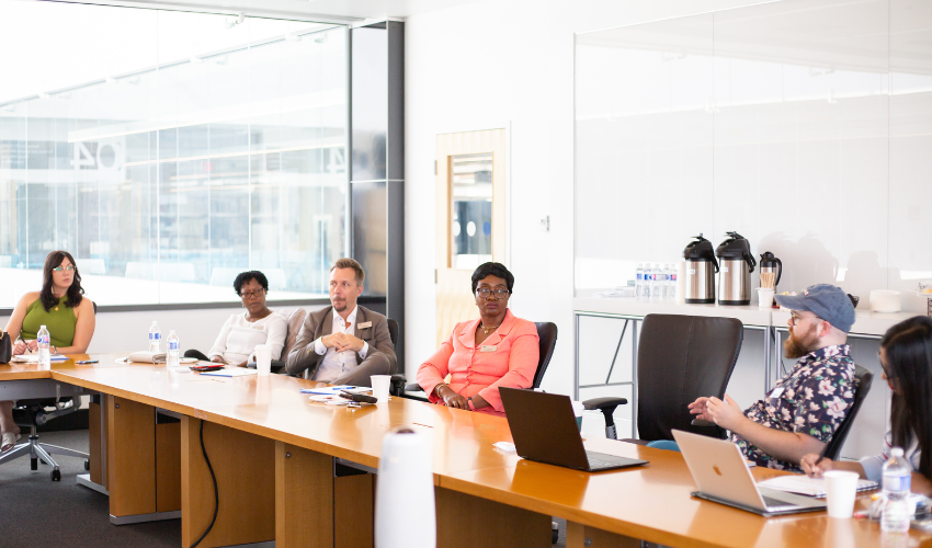 A group of people having a meeting in the boardroom of the Riddell Library and Learning Centre.
