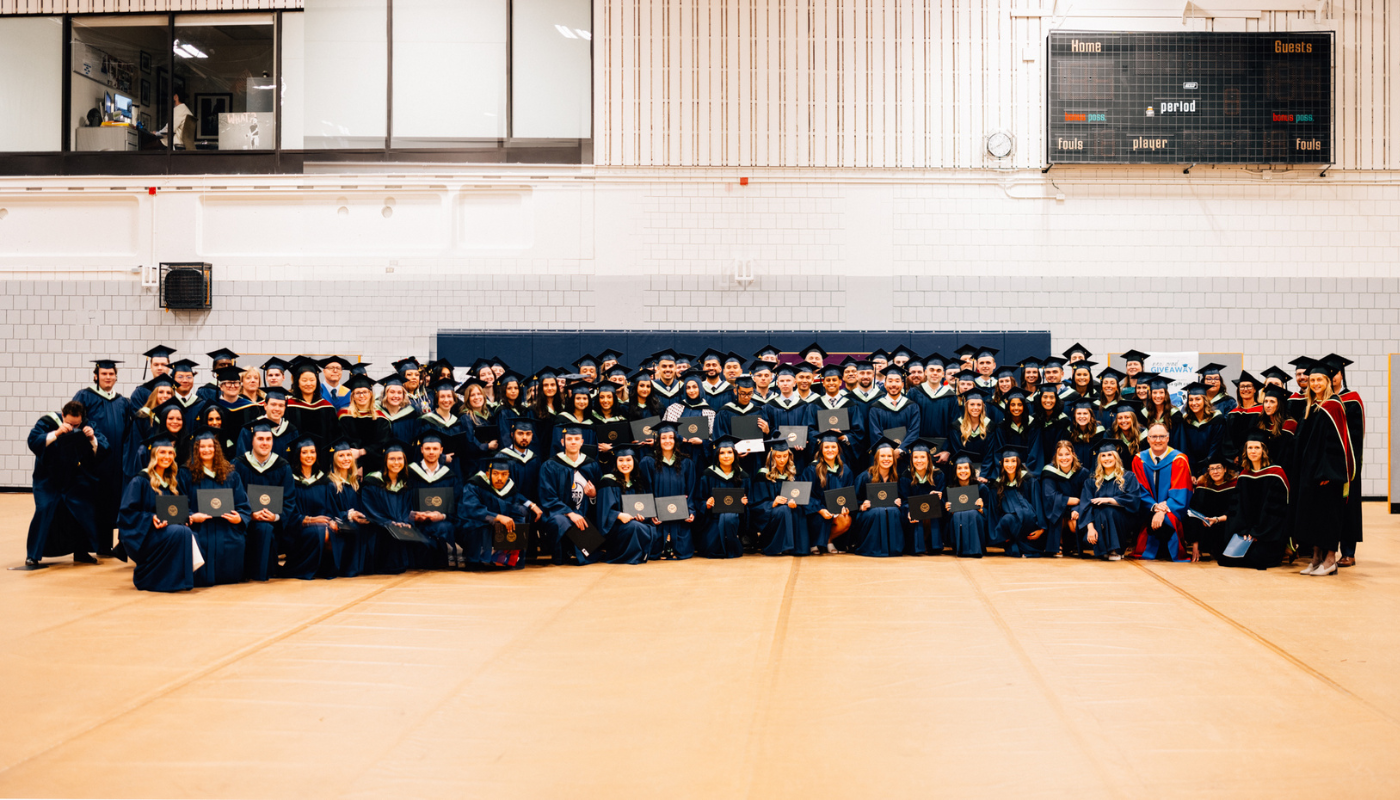 Rows and rows of convocating students posed as a large group in their regalia.