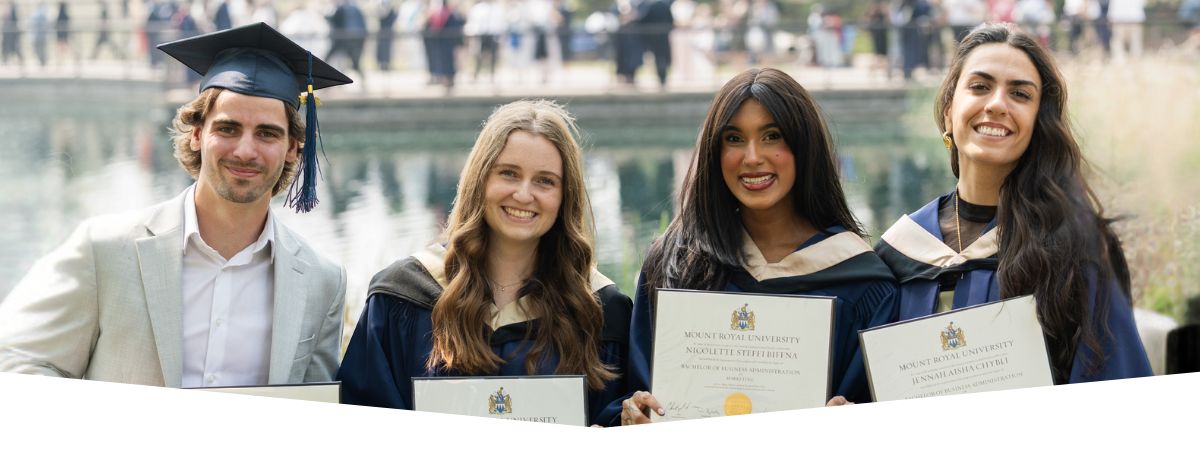 A group of new grads taking a celebratory photo out by the Charlton Pond