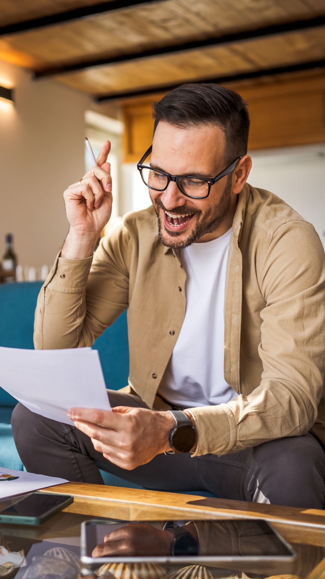 A person excitedly looking at a pile of papers and pointing in up in revelation.