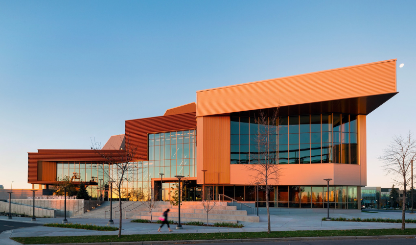 The Taylor Centre for the Performing Arts at dusk. It is a geometric copper and glass building