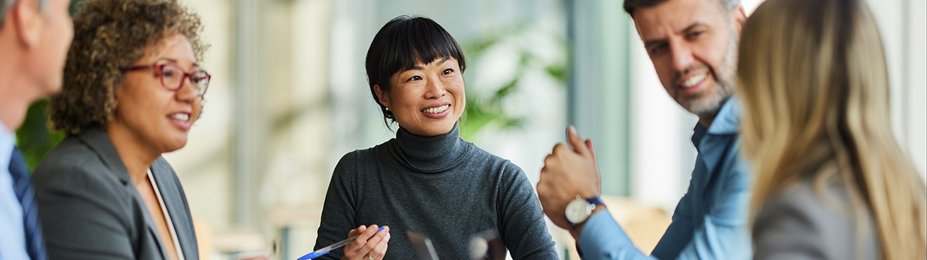 Group of happy multiracial entrepreneurs communicating during a meeting in the office. 