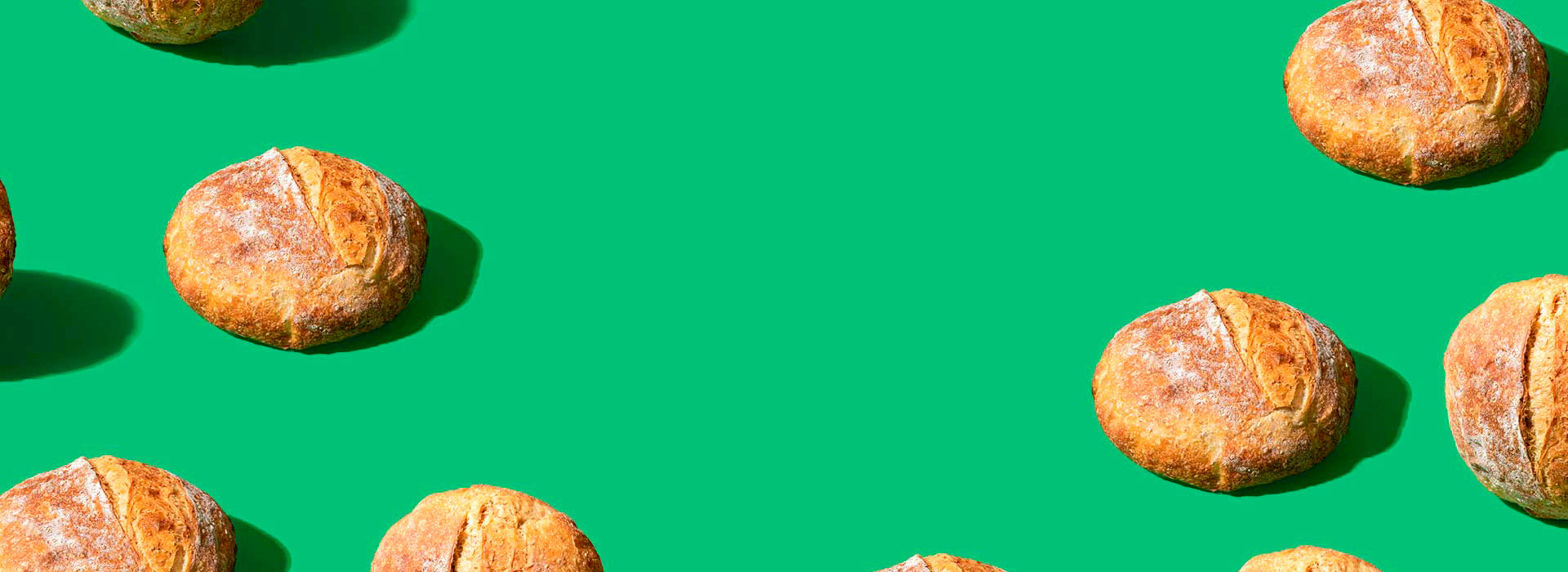 A pattern of pieces of boules of bread on a green background.