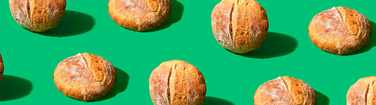 Boules of bread in a pattern on a medium green background.
