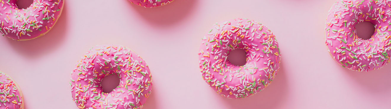 A pattern of pink sprinkle doughnuts 