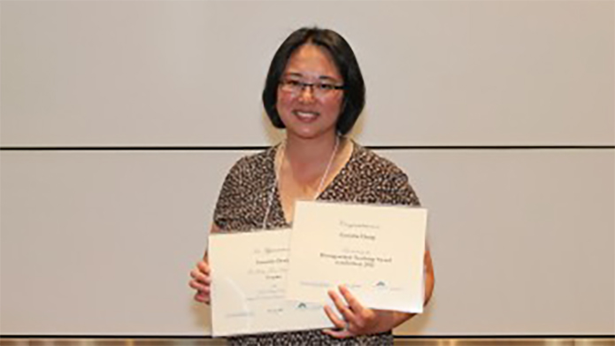 Photo of Cornelia Chang holding some awards.