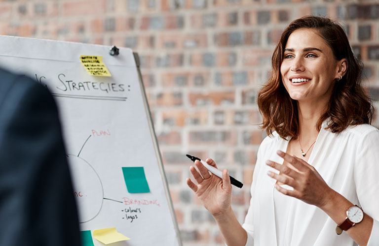 Shot of a young businesswoman presenting notes on a whiteboard in an office.
