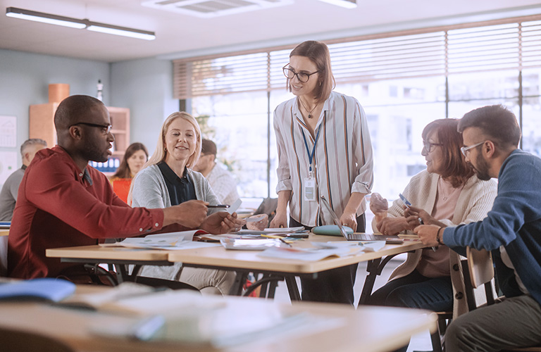 Adult education professional instructing adult students in a classroom.