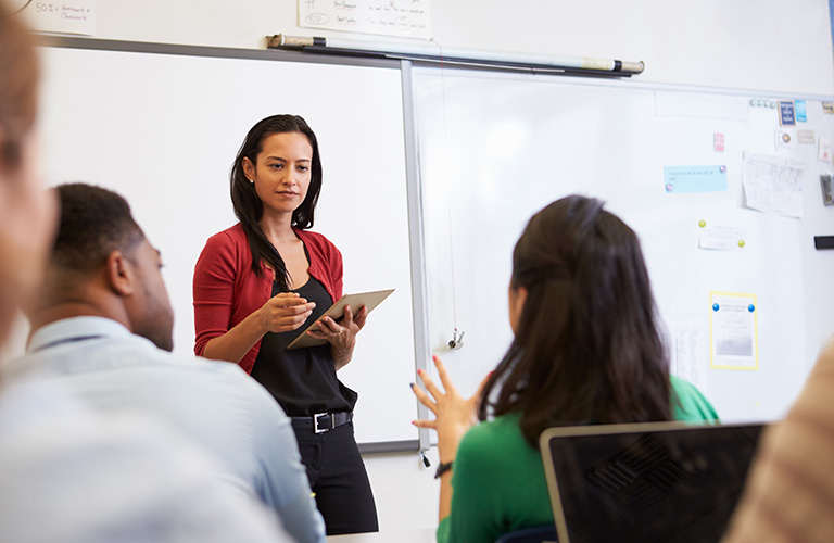 Instructor leading a class of adult learners.