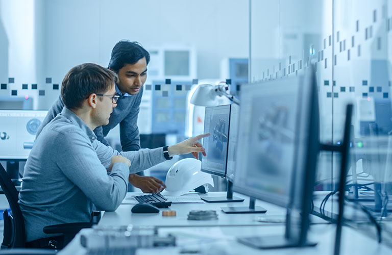 Two professionals looking at a 3D model on a computer screen.