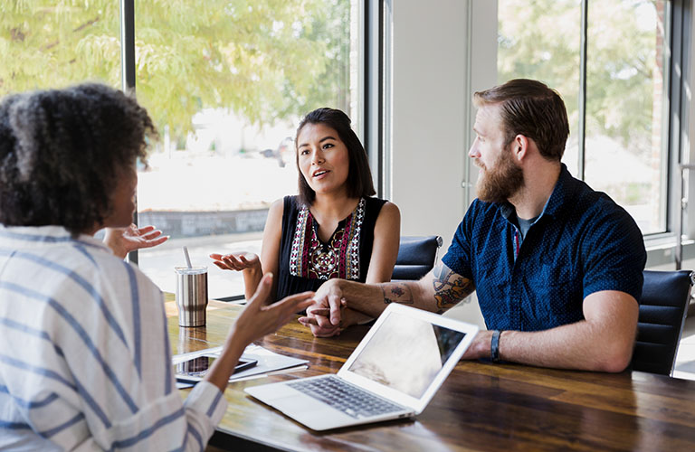 A mediation professional talking with an adult couple.