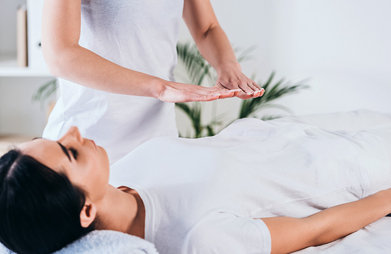 Person providing a Reiki treatment on a client.