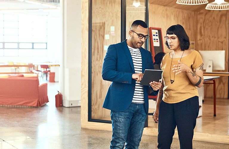 Two professionals looking at at a tablet.