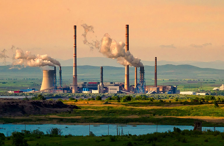 Large structures including smoke stacks in a large field.