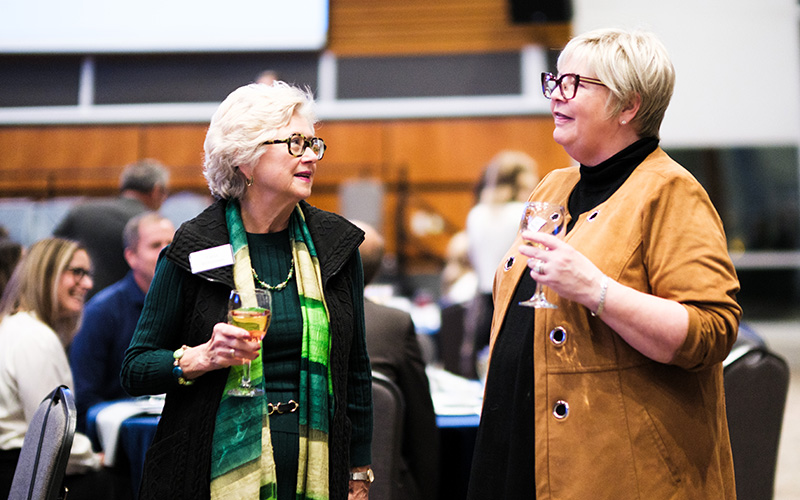 Two employees chatting at the CelebtrateU Award ceremony.