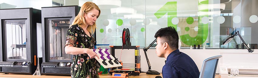 Maker Studio Specialist, Kerry Harmer shows different 3D printed objects to a student.