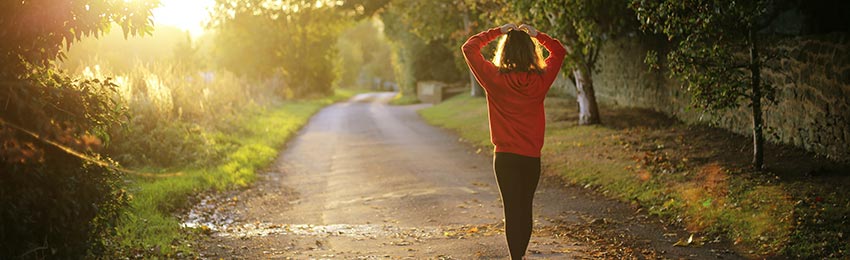 A person walking down a path in exercise clothes.