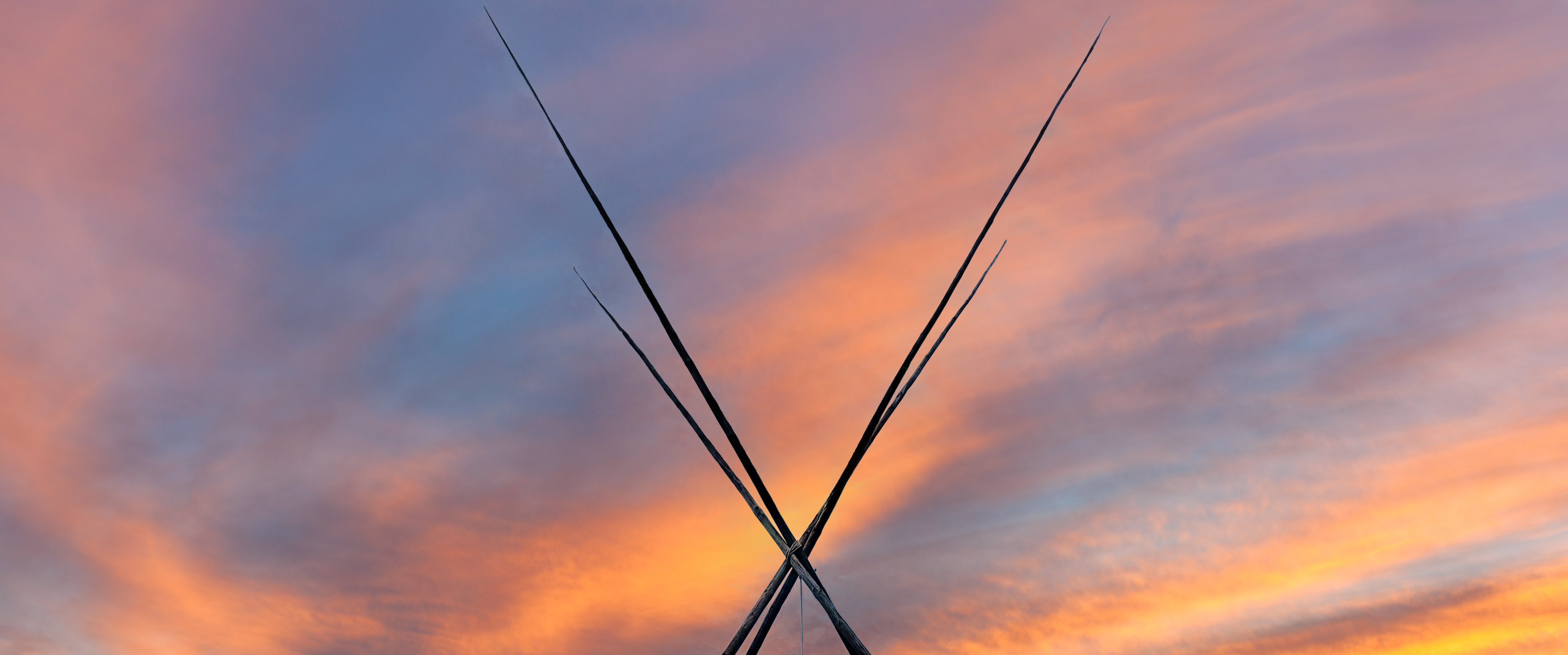 the four foundational poles against a pink and orange sunset