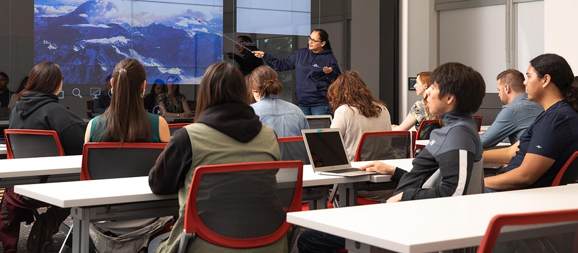 A groups of students listening to an Indigenous student give a presentation