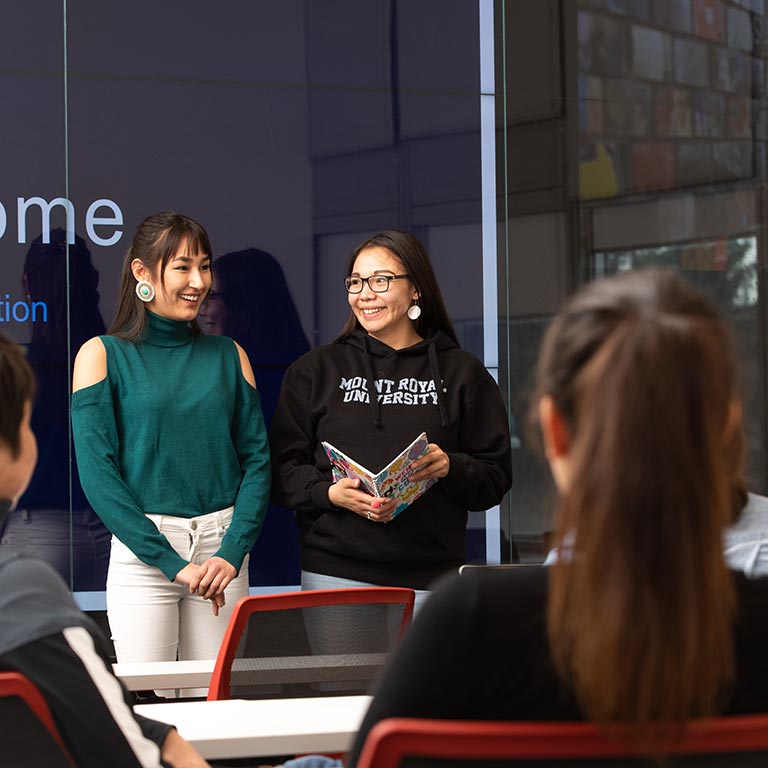 Two Indigenous students giving a presentation in Visualization Classroom