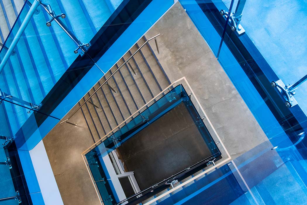 A photo of pointing down the bright blue stairwell in the Riddell Library and Learning Centre. 