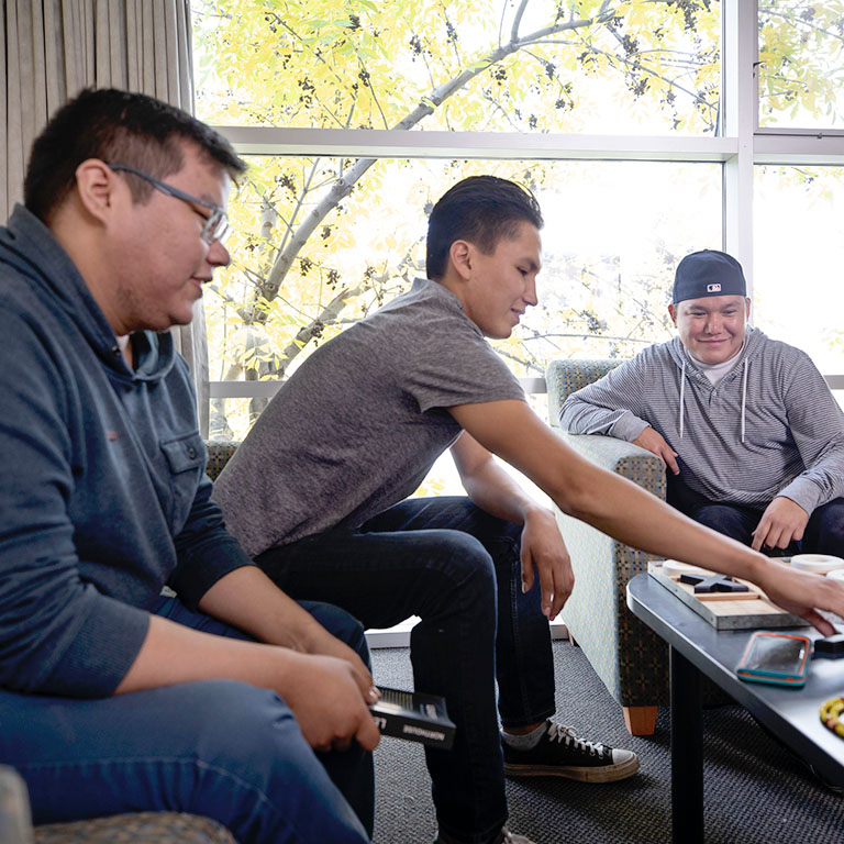 Three students hanging out in Mount Royal's West Residence