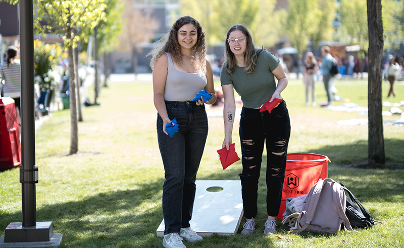 Two students playing a lawn game on a sunny day on East Gate lawn.