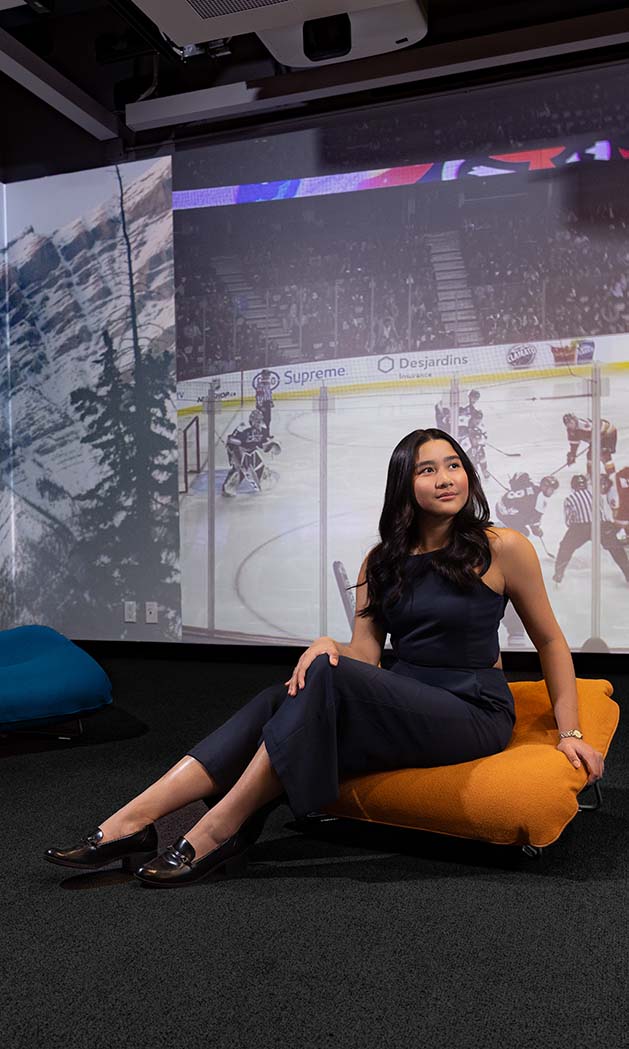 Nina Petinglay sitting on a cushion in the Riddell Library and Learning Centre's Immersion Studio.