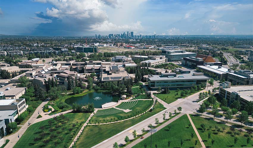 Drone shot of the entire Mount Royal University campus with downtown Calgary and a moody sky in the background.