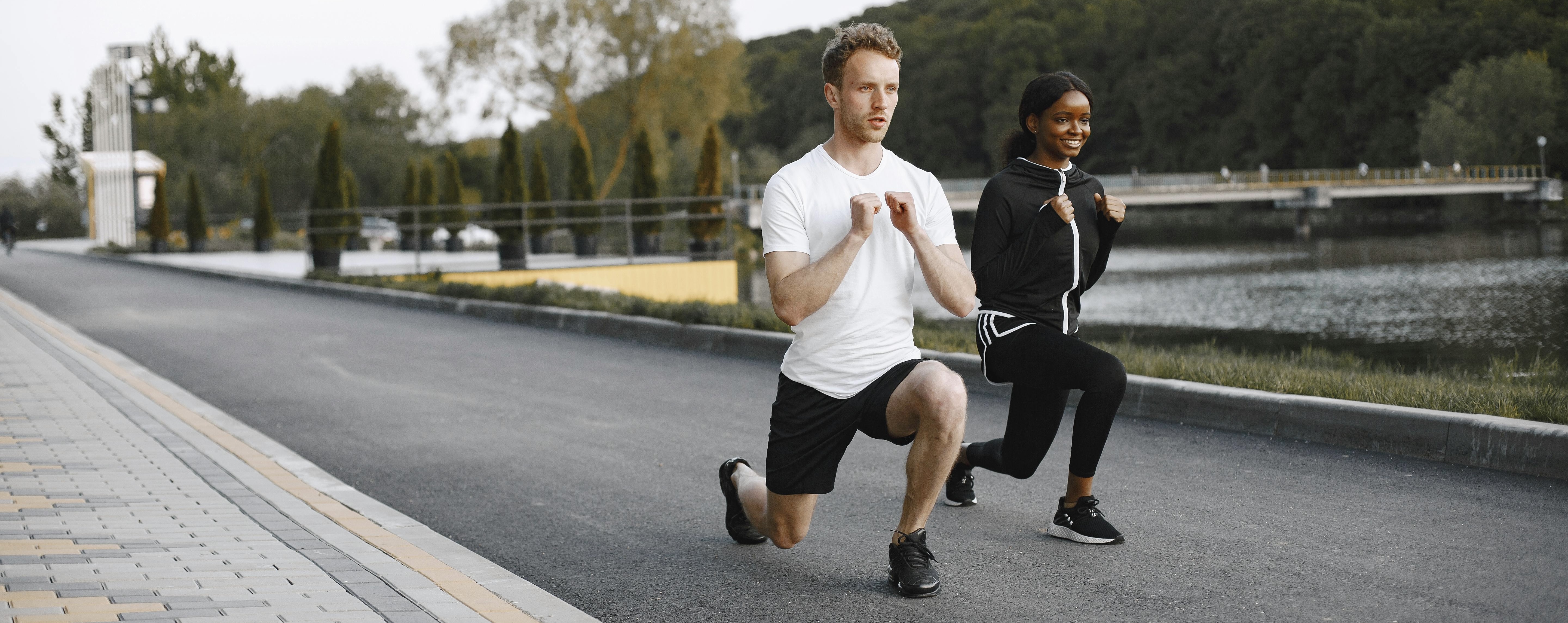 A man in a black jacket performs a squat, focusing on his form and balance